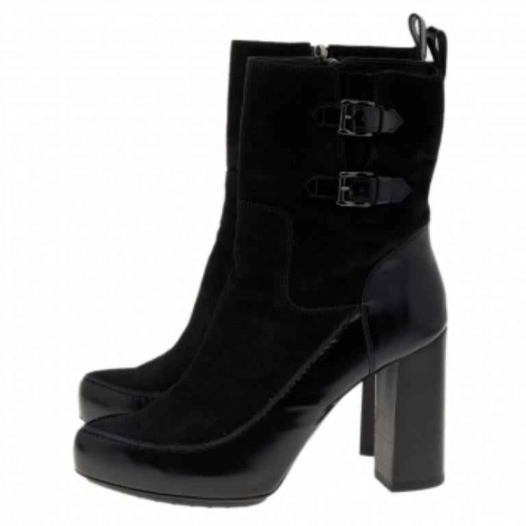 Apportez une touche de classe à vos pieds avec ces bottes de la maison Tod's. Elles sont fabriquées en daim noir et en cuir sur l'extérieur et présentent des orteils recouverts, des accessoires de couleur bronze et une fermeture à glissière. Portez
