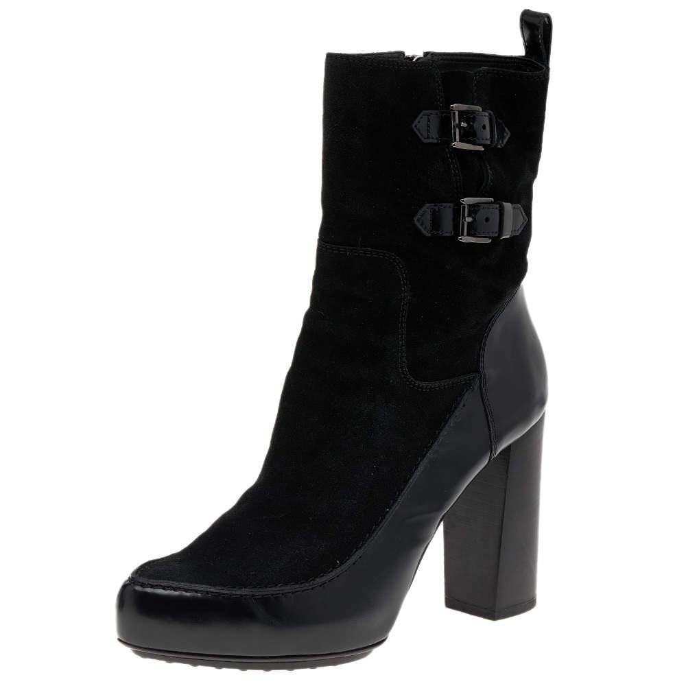 Add a classy touch to your feet with these boots from the House of Tod's. They are made from black suede and leather on the exterior and showcase covered toes, gunmetal-toned hardware, and zipper closure. Wear these boots and amp up your trend