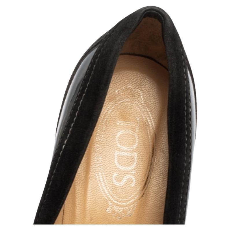 Step out in sophistication and style when you don this pair of smart pumps by Tod's. Sturdy and durable, these pumps have been crafted out of suede and patent leather. They come in a classic shade of black and have lace-ups on the toes, signature