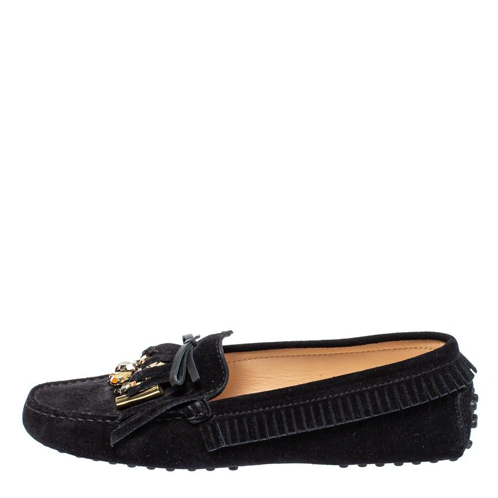 Sleek and luxe, these loafers by Tod's will enhance your ensembles by giving them an edge. Meticulously crafted from black suede, they carry fine stitching with bows, fringes, and dazzling embellishments on the vamps. The pair is complete with