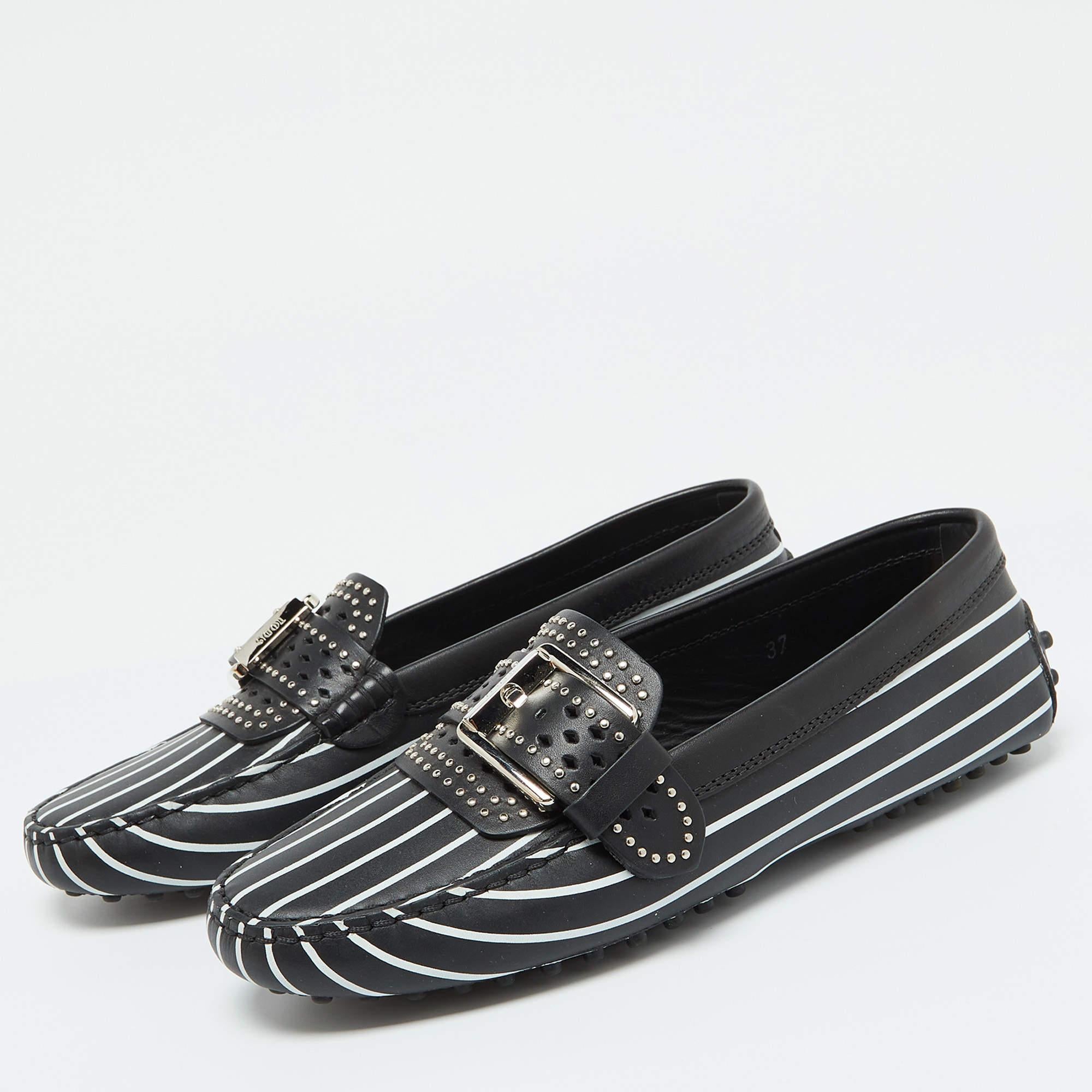 The white stripe detailing against the black exterior lends this Tods loafers a luxe contrast. Constructed from leather they are made eye catching with embellishments and flaunt a slip on fitting. The leather and rubber soles of this pair will fill