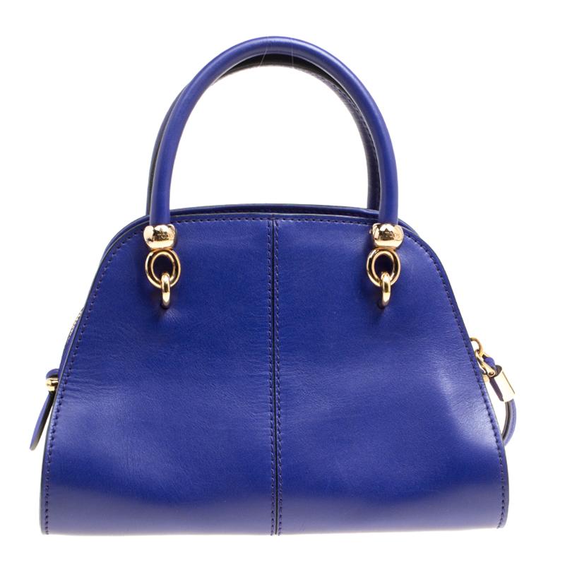 Flaunt this blue bowling bag from Tod's at work and receive a trail of compliments! Crafted from leather and suede, the bag features dual rolled handles, a detachable shoulder strap, gold-tone hardware and a sturdy base. The small 'Sella' bag with