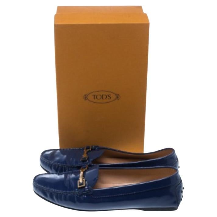 Confectionnée en cuir verni et dotée d'une silhouette soignée, cette paire de mocassins bleus signée Tod's est un véritable mélange de luxe et de confort. Fabriquées en Italie, elles présentent des bouts ronds, des boucles à cheval dorées avec un