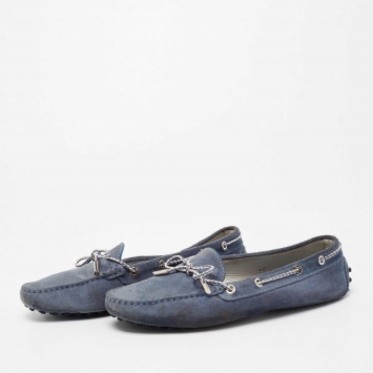 Diese Loafer von Tod's werden mit Sicherheit zu den begehrtesten Stücken in Ihrem Kleiderschrank gehören. Sie sind aus Wildleder gefertigt und mit einer Schleife auf der Oberseite und Kieselsteinchen auf der Sohle versehen. Ein beeindruckendes Paar