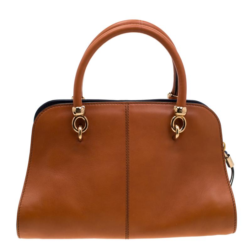 Passé par un processus rigoureux de couture fine, ce Sella by Tod's vous est offert avec amour. Son corps en cuir est orné de coutures soignées parfaitement symétriques, de deux poignées galbées sur le dessus et d'un intérieur en satin fermé par une