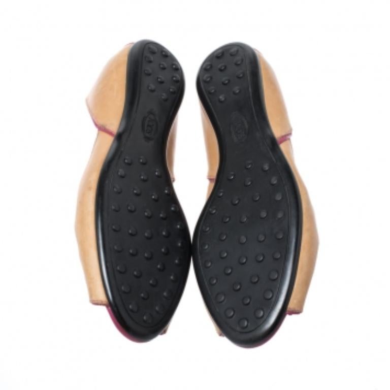 These chic ballet flats from Tod's will make your feet look pretty and fashionable. They are crafted from leather and accented with patent leather trims. They feature cutout and tie-ups on the vamps, peep toes and pebbled outsoles. These brown flats