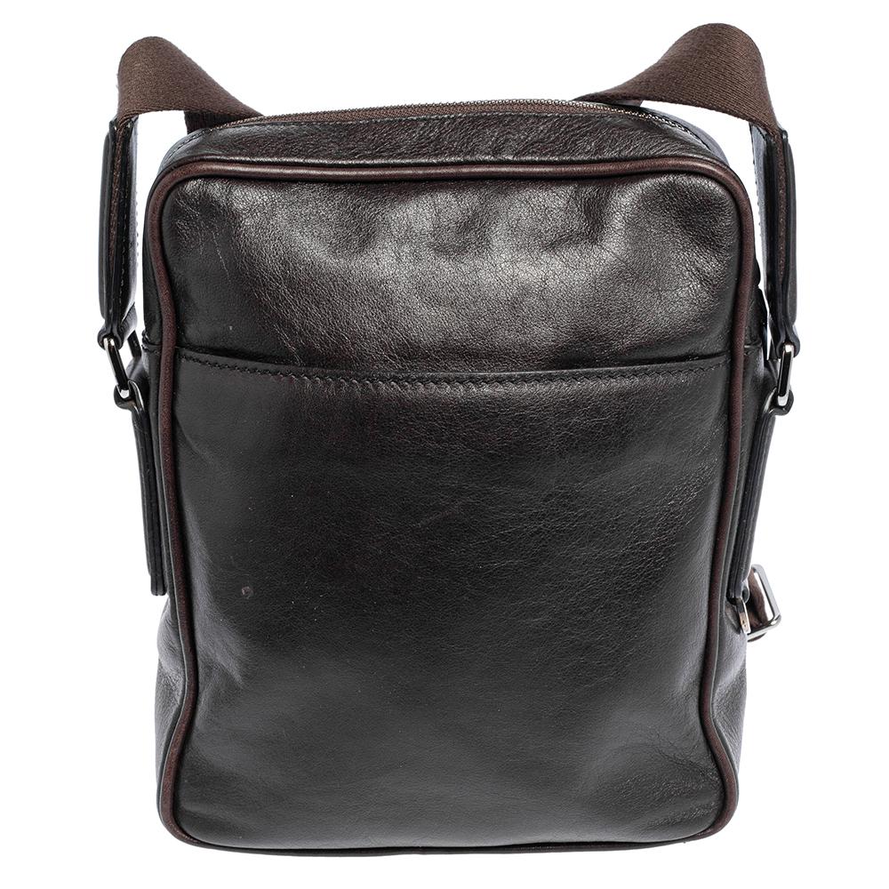 This messenger bag from Tod's, made from brown leather, offers practical ease and classic style. Equipped with a front pocket, the main fabric interior, gunmetal-toned hardware, and an adjustable strap, this bag will effortlessly hold your