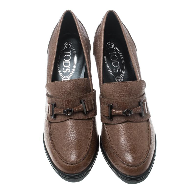 Super-comfortable and loaded with style, this pair of loafer pumps by Tod's will effortlessly complement your workwear. They've been crafted from brown leather and styled with buckles and block heels.

Includes: Packaging