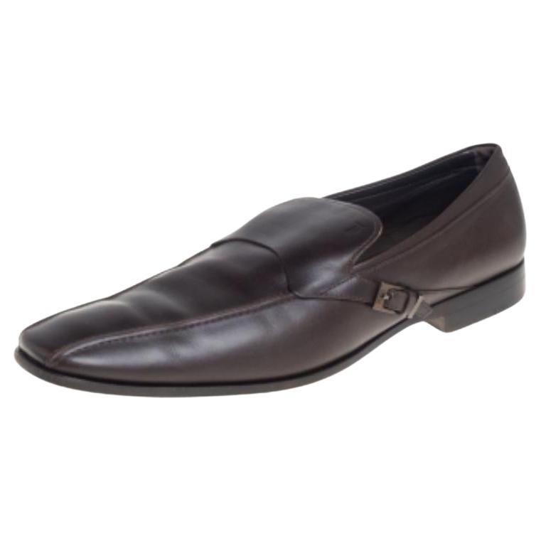 These slip-on loafers from Tod's are the ideal pair you'll love having in your closet. They are crafted from leather in a smart brown color and feature square toes and buckle strap details on the sides. They are complete with comfortable