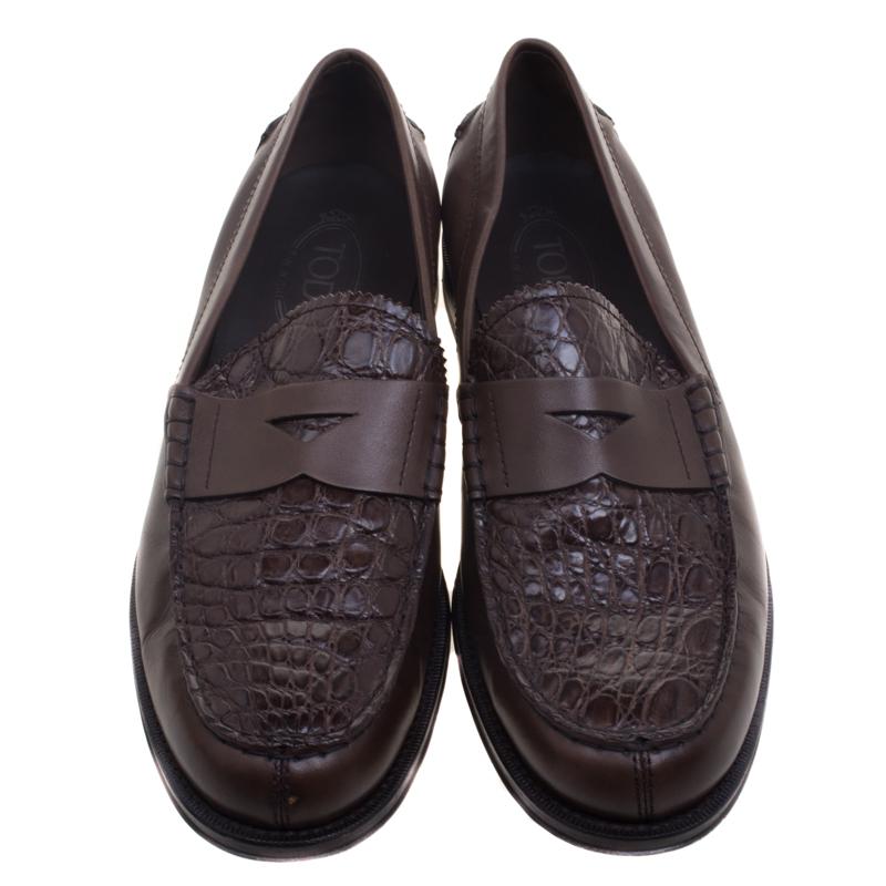 Crafted from exotic leather and styled into an edgy silhouette, this pair of brown Penny loafers by Tod's is a true blend of luxury and comfort. Made in Italy, they feature a penny keeper strap, and leather lined insides housing the brand label. The