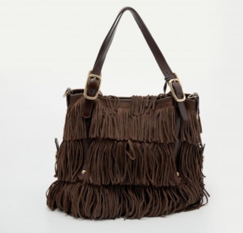 Con un diseño elegante y un acabado impecable, este bolso Tod's es imprescindible por todos los motivos. Fabricado en ante y piel, tiene flecos, dos asas y una correa para el hombro. Se abre a un espacioso interior en el que caben fácilmente todos