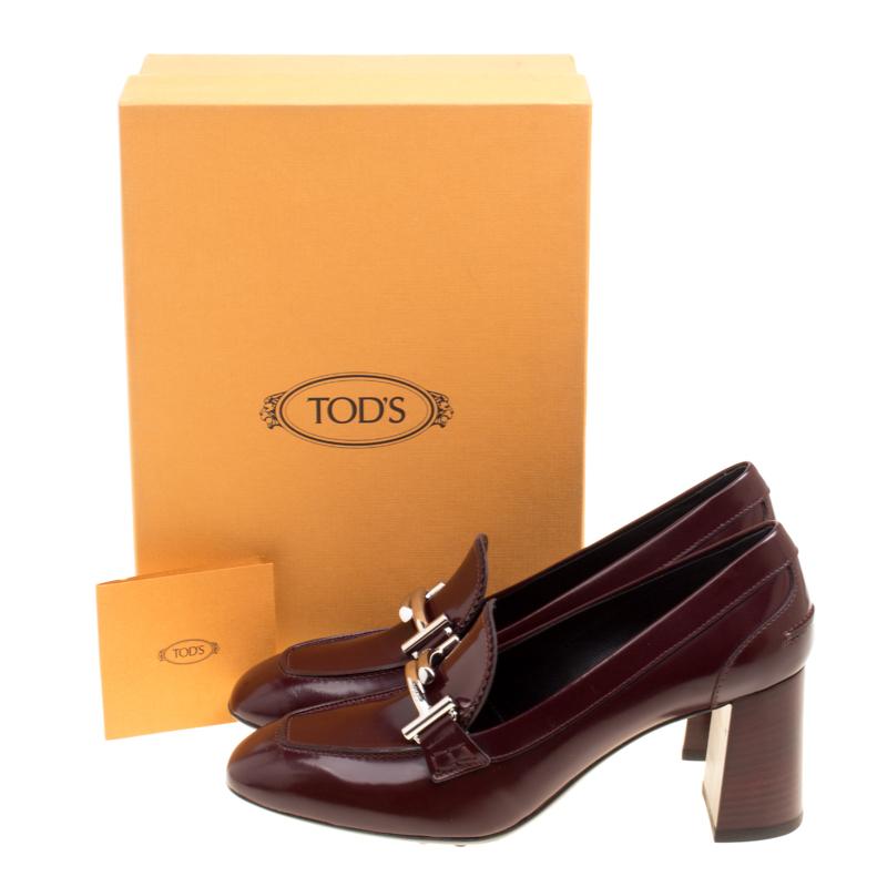 Designed in a very unique and eye-catching style by Tod's, these Gomma Maxi Court loafer pumps are sure to be a conversation starter. Crafted from burgundy leather, these pumps feature silver-tone double T buckle detailing on the vamps and block