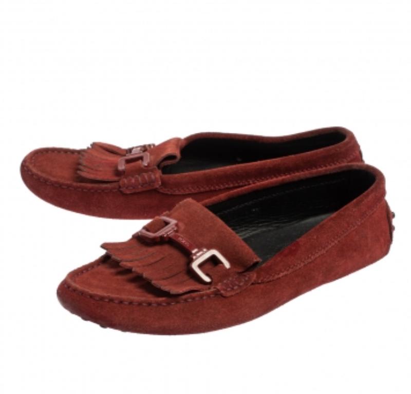 Finish your casual look with style and class by putting on these loafers by Tod's. Crafted from burgundy suede, it features fringe and metal accents on the vamps. They come with leather-lined insoles and carry brand labeling.