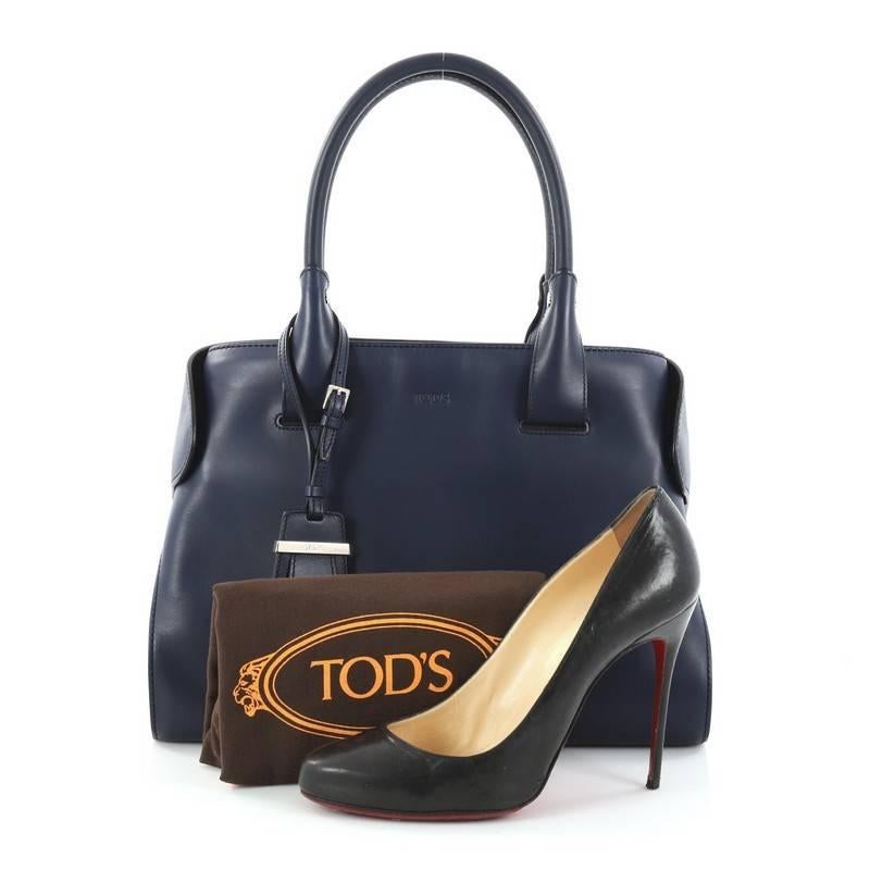This authentic Tod's Cape Satchel Leather Small is an elegantly structured bag perfect for your everyday looks. Crafted from navy leather, this chic bag features dual-rolled leather handles, magnetic fastening fold over corners, subtle stamped Tod's