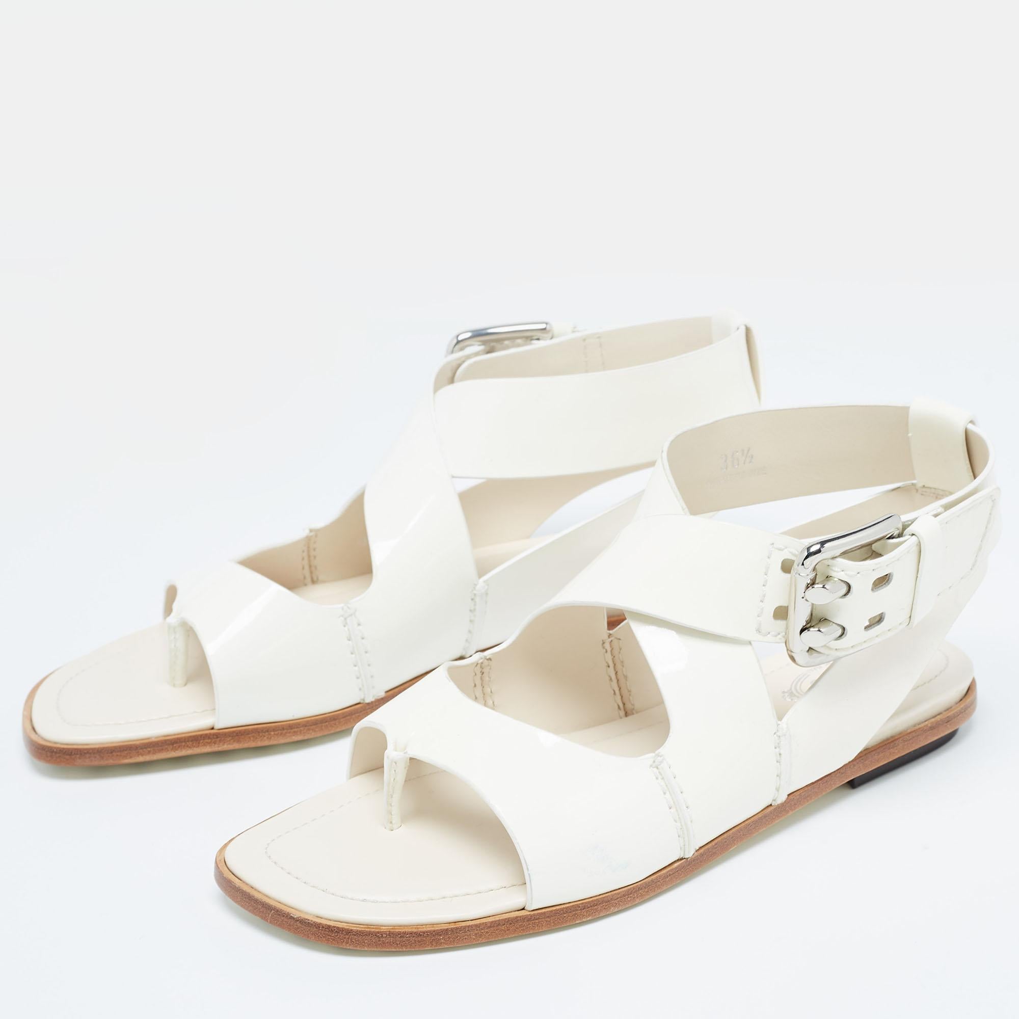 These Tod's flats are designed from patent leather and they offer maximum comfort. Flaunt the fashionista in you with these white sandals that come with the iconic pebbled soles and have cross straps with buckle closures. Team them with a pretty
