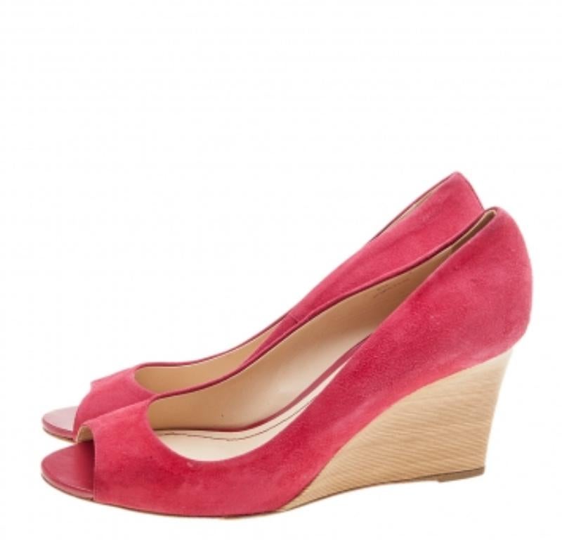 Made in a subtle crimson red shade, this pair of Tod's pumps has a classy look. The suede creation has been styled into a peep-toe silhouette and features a comfortable rubber sole and a wood-like wedge heel.