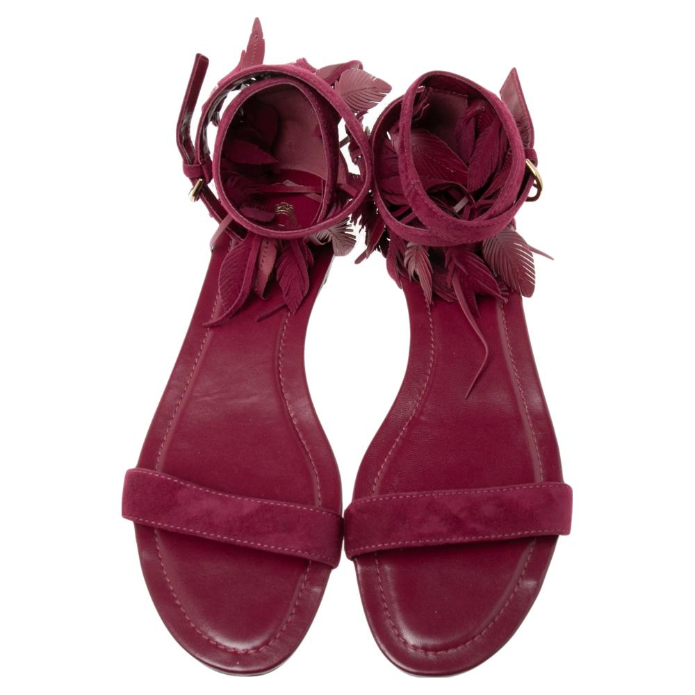 Beautifully made, these sandals from the House of Tod's will make your style look spot-on and trendy. They are made from deep-magenta suede with fringe detailing on the ankle strap. These flat sandals are decorated with gold-toned hardware. Pair