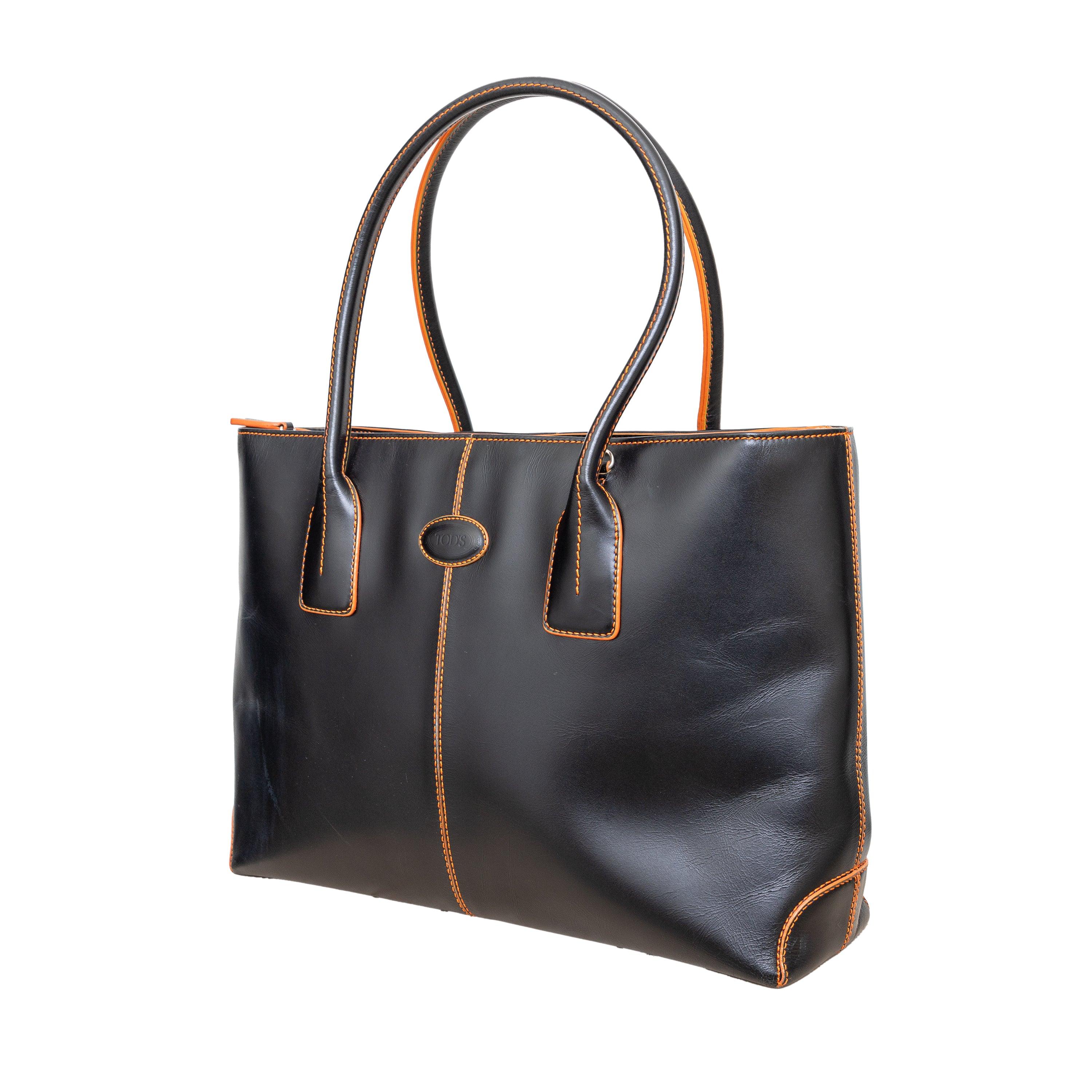 The Tod's Di Bag is timeless and elegant, made with the finest calfskin leather for a silky feel and natural grain. This exclusive version features black leather, orange stitch detailing, and silver-tone hardware. With two top handles, a removable