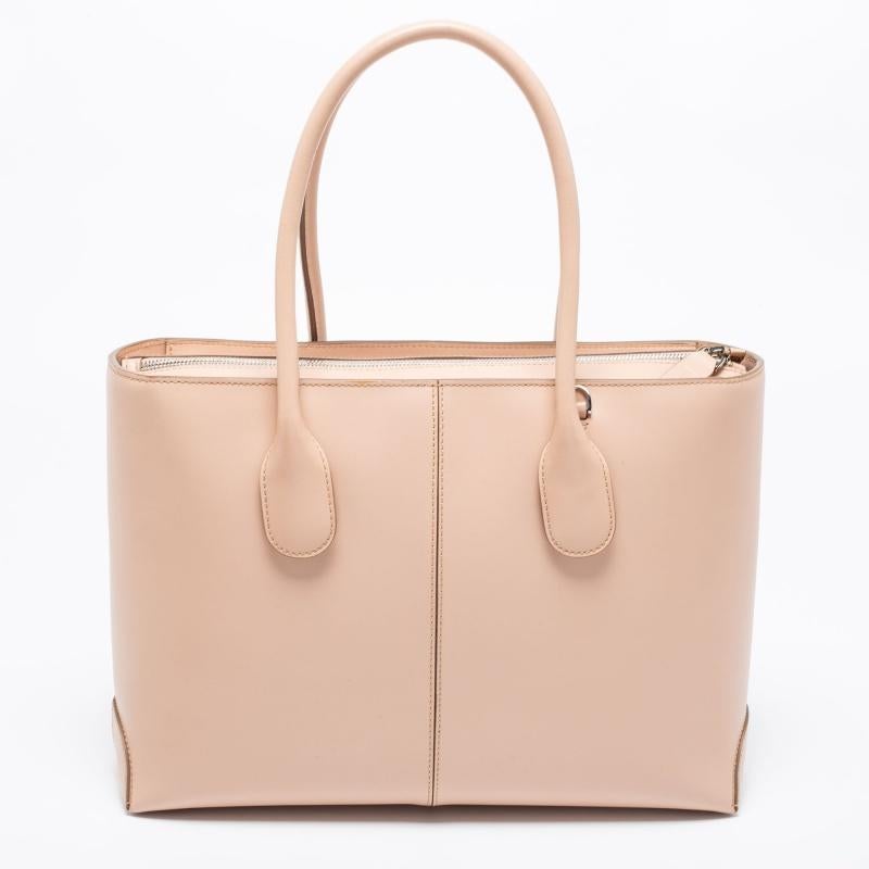 Coming from Tod's is this pink tote that is the perfect day bag. It is crafted from leather into a structured shape and flaunts silver-tone details, dual handles with a detachable strap, and a zipper that reveals a capacious interior for your