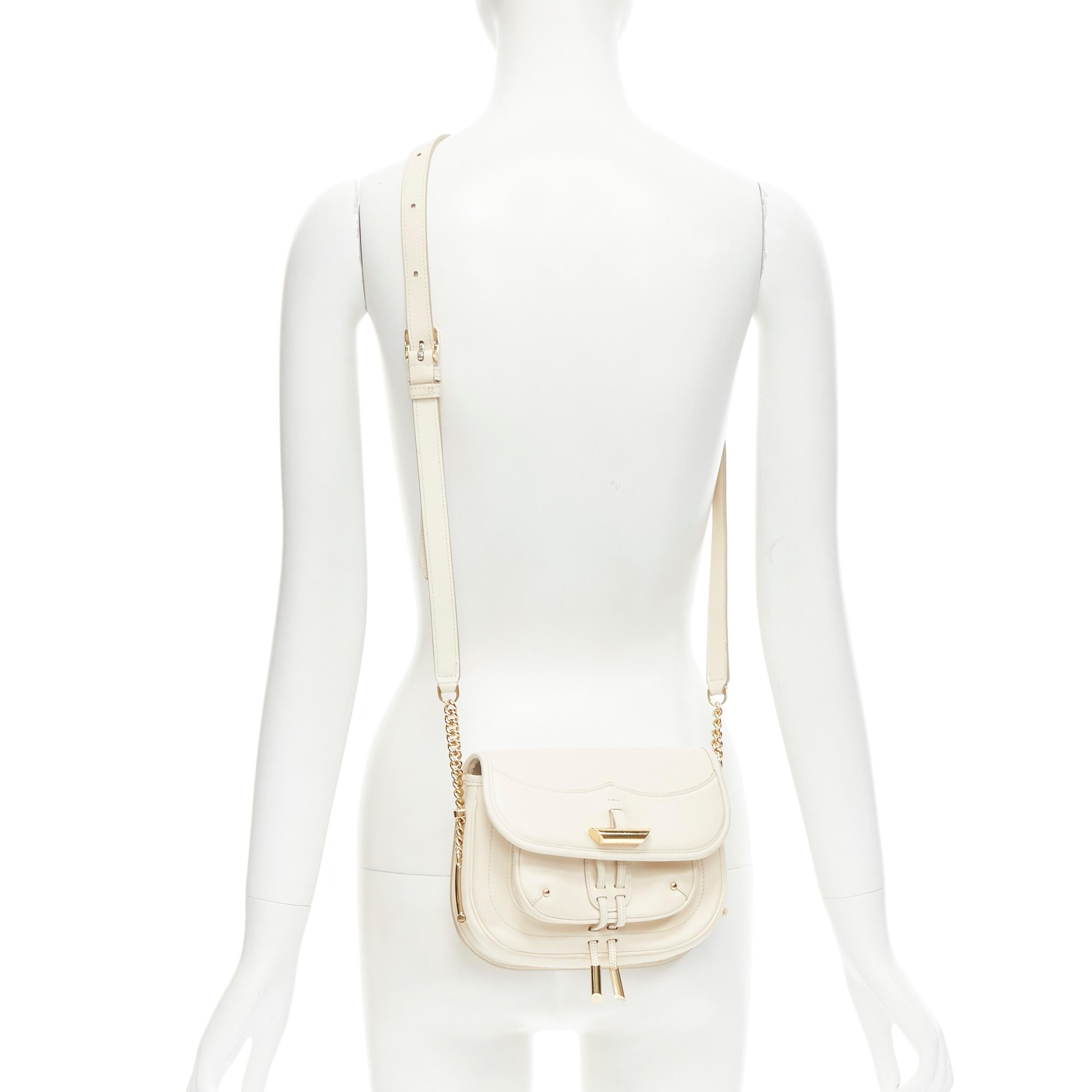 TOD's Fiocco cream beige gold toggle hardware crossbody saddle bag 
Reference: MAWG/A00062 
Brand: Tod's 
Model: Fiocco 
Material: Leather 
Color: Cream 
Pattern: Solid 
Closure: Magnet 
Extra Detail: Cream leather with gold-tone hardware. Gold-tone