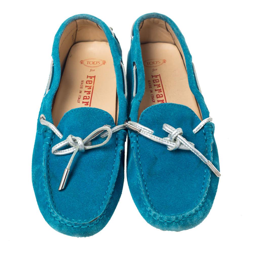 Set trends with these loafers from the house of Tod's. Meticulously crafted from suede, they are from their collaboration with Ferrari. They feature a smart teal blue exterior with bow detailing and Ferrari's logo. The loafers are complete with
