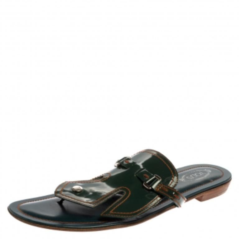 Edgy and stylish, these stunning Tod's flats are perfect for day outings. These are crafted from glossy patent leather and are styled with silver-tone buckle detailing. It has a thing design, low heels, leather-lined insoles and soles.