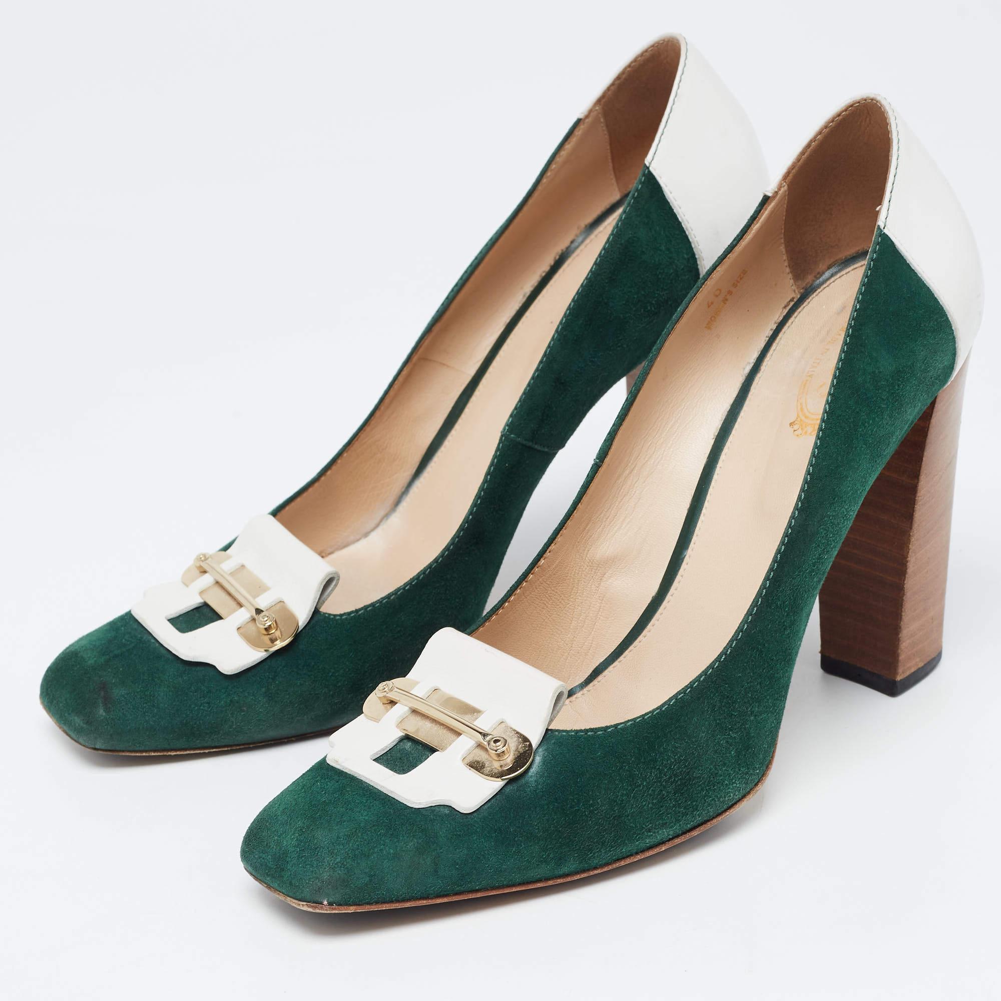 Tod's ofrece una elegancia sencilla para la mujer moderna con estos magníficos zapatos de salón perfectos para la oficina y los eventos informales. Confeccionadas en ante y piel, las aberturas están decoradas con herrajes dorados. El conjunto se