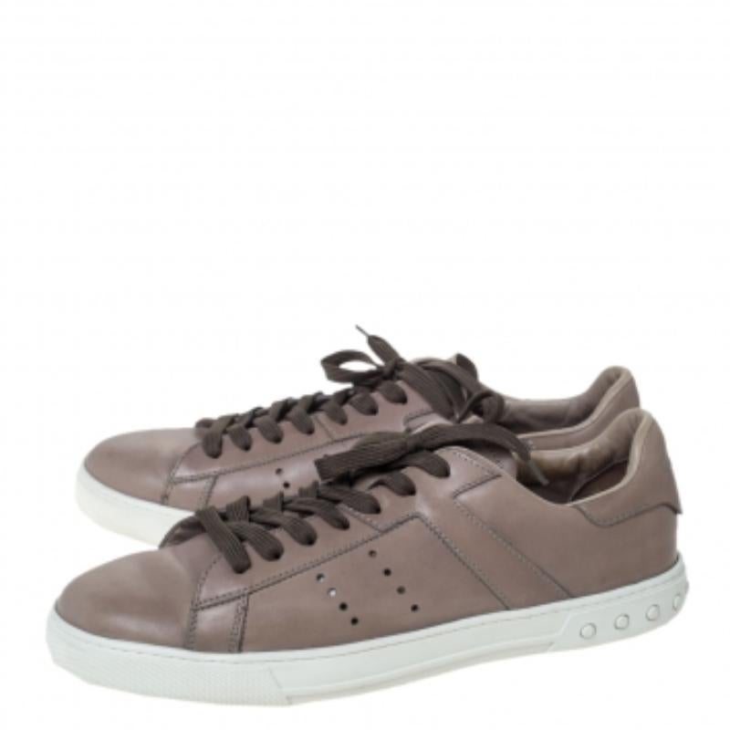 Diese stylischen Low-Top-Sneaker von Tod's gehören diese Saison Ihnen. Sie werden in Italien in sorgfältiger Handarbeit aus grauem Leder gefertigt. Sie haben eine runde Zehenpartie, ein geschnürtes Oberteil, perforierte Details, ein Markenlogo auf