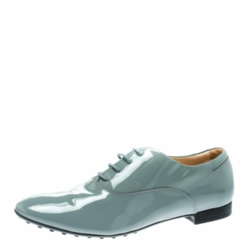 Ces Tod's en cuir verni sont brillants et très élégants. De couleur grise, elles sont dotées de bouts ronds, de lacets et d'une semelle extérieure en galets. Les oxfords peuvent être portés avec une robe ou un jean slim et un joli haut.