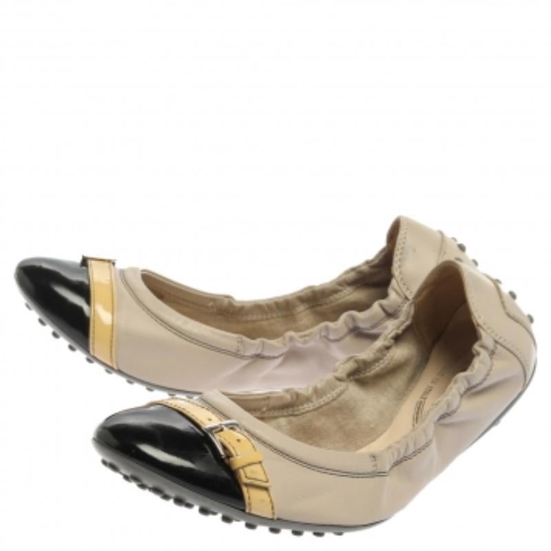 These Tod's ballet flats are elegant and luxe. Crafted from beige leather and black patent leather, they flaunt cap toes with buckle detailed straps on them and a scrunch style to give you a good fit. The pair is complete with pebbled rubber