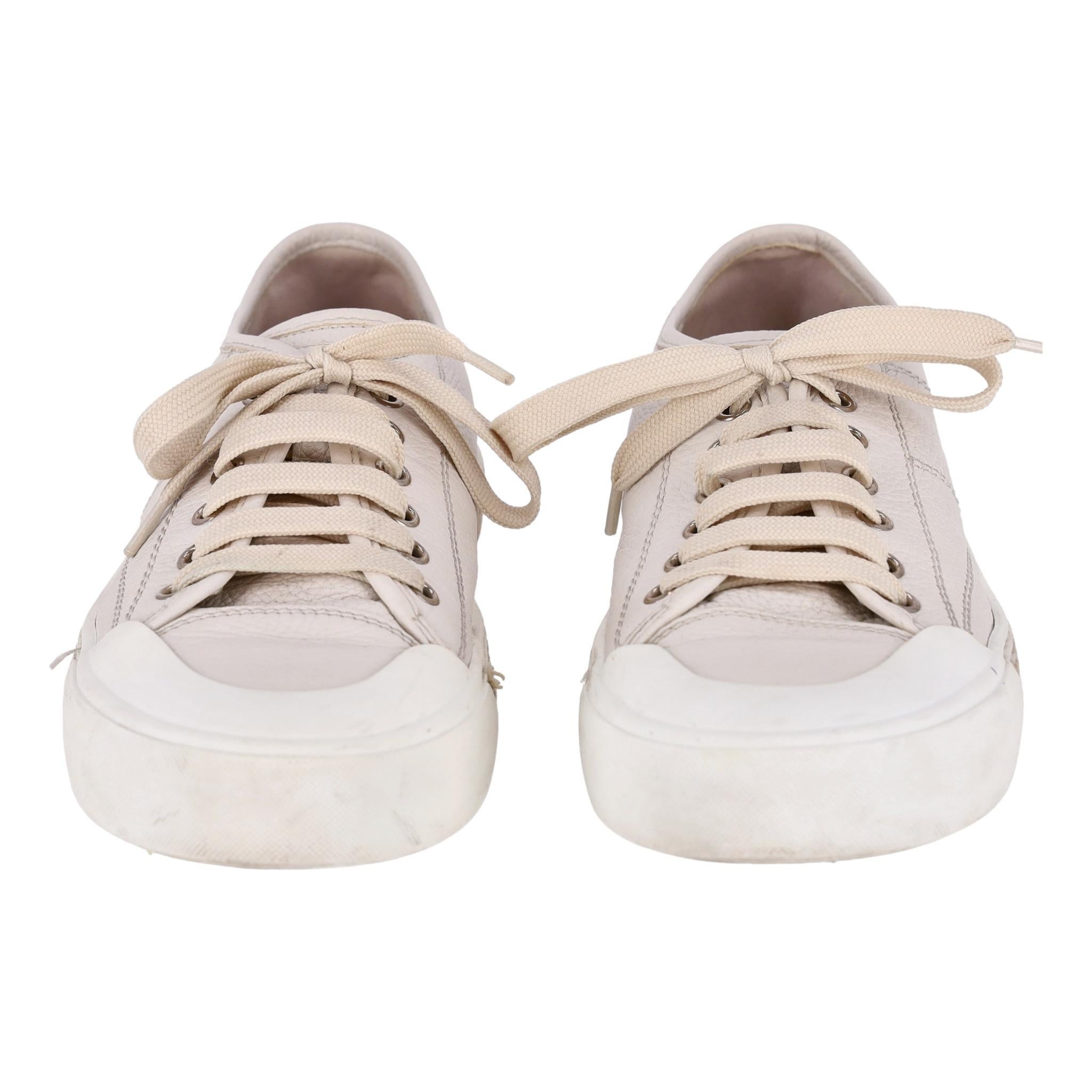 Tod's Leather Sneakers

Ivory low-top sneakers crafted in leather with brown braided soles.

Featuring lace-up front with round toe Tod's embossment to the tongue.

Size – 39

Condition – Good (Minor mark, some scratches and pulls)

Composition –