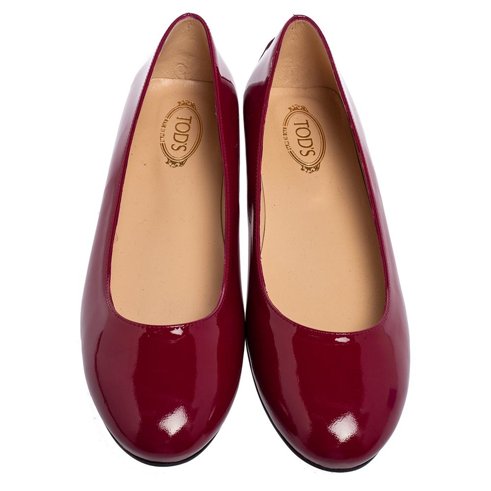 There are some shoes that stand the test of time and fashion cycles, these timeless Tod's ballet flats are the one. Crafted from patent leather in a magenta shade, they are designed with sleek cuts, round-toes, and comfortable insoles.

