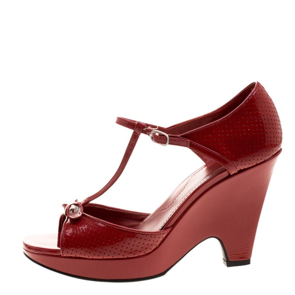 A classic combination of style and ease, these Tod's wedges is something every modern-day wardrobe should have. Set on comfortable block heel and platform sole, this pair features a maroon patent leather body and secured with an ankle strap closure.