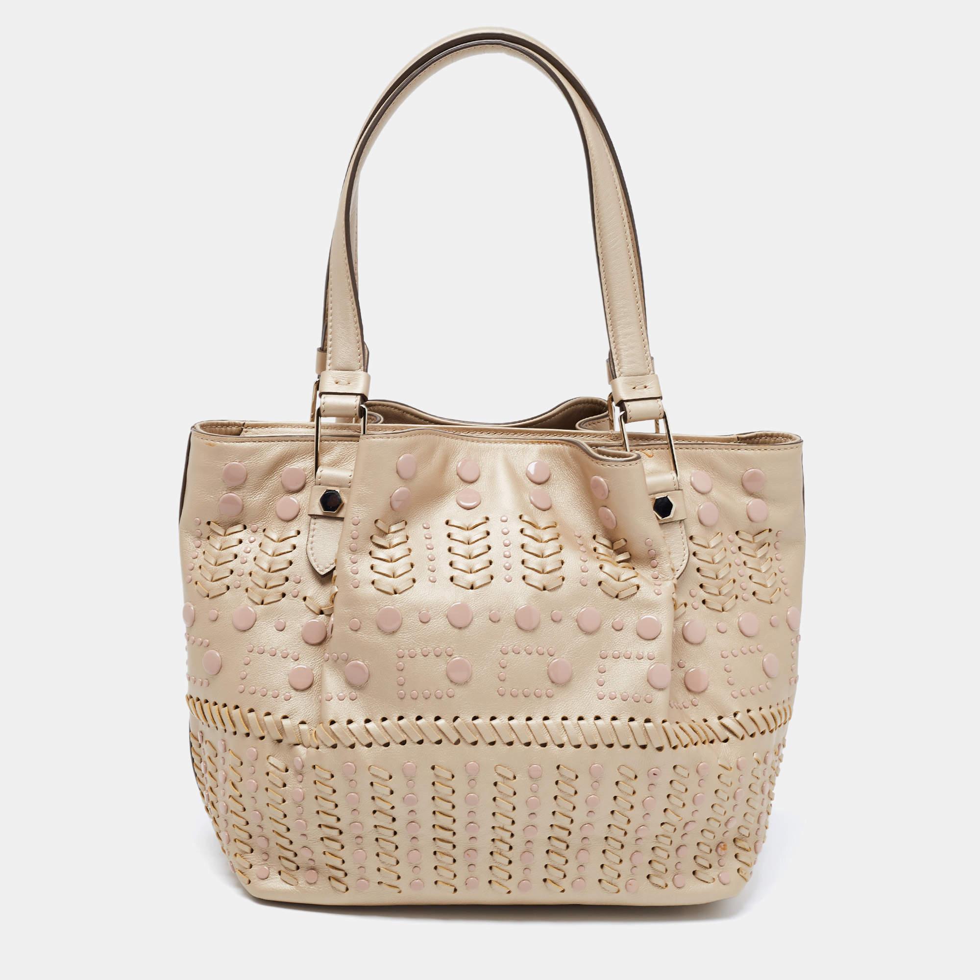 Tod's delivers a beautifully-made tote in beige leather to assist you to lunch or shopping. This lovely tote is decorated with studs and sized spaciously for neatly housing your belongings. Two handles on top allow easy carrying options.
 
Includes:
