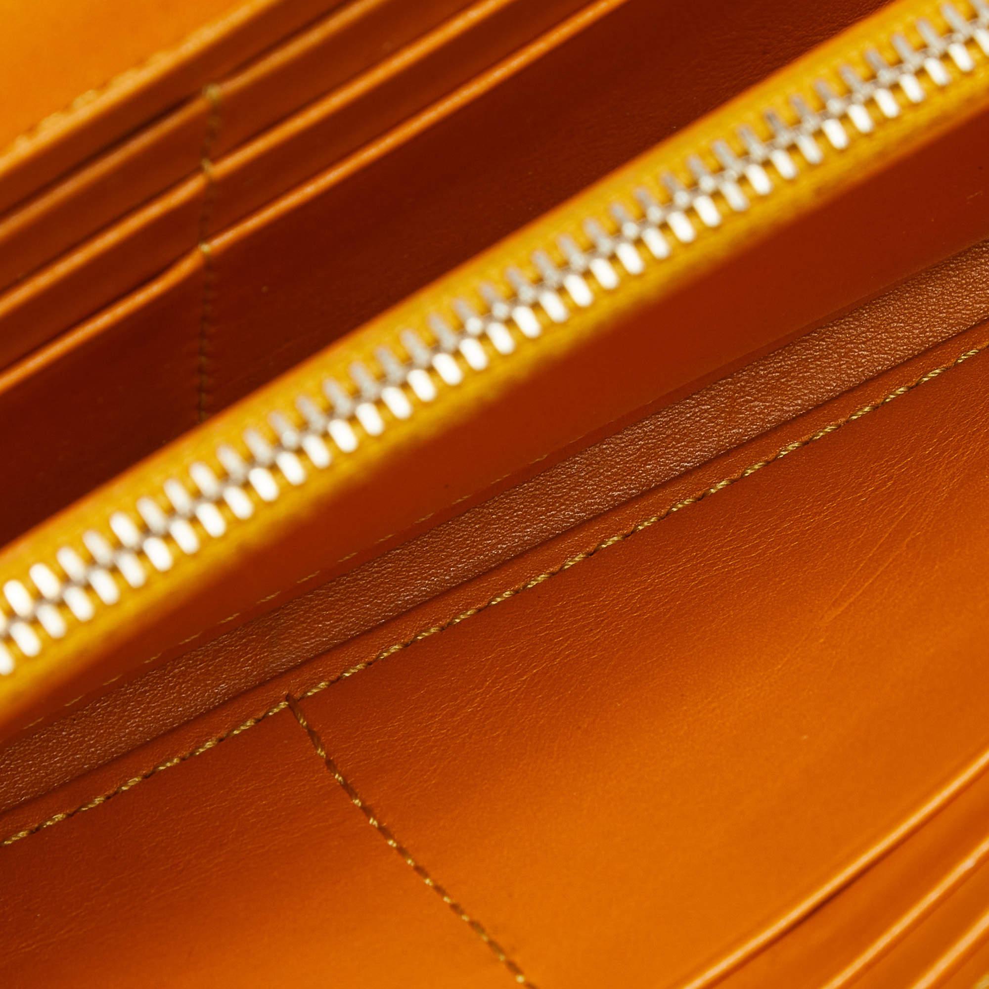 Durable and long lasting this wallet from Tods is crafted from leather. Featuring a lovely mustard shade it flaunts a front flap that is adorned with a silver tone brand logo plaque and opens to a leather interior that houses a zip pocket and