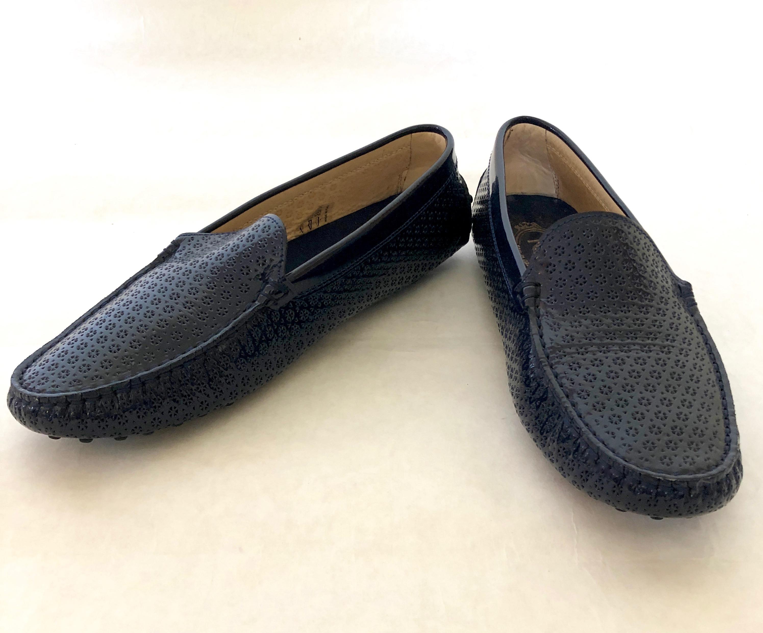 Make:  Tod's
Place of Manufacture:  Italy
Size:  39
Color:  Navy Blue
Materials:  Patent leather and rubber
Style:  Floral pattern perforated navy blue patent leather driver / moccasin with the Tod's pebbled no slip rubber sole and back of