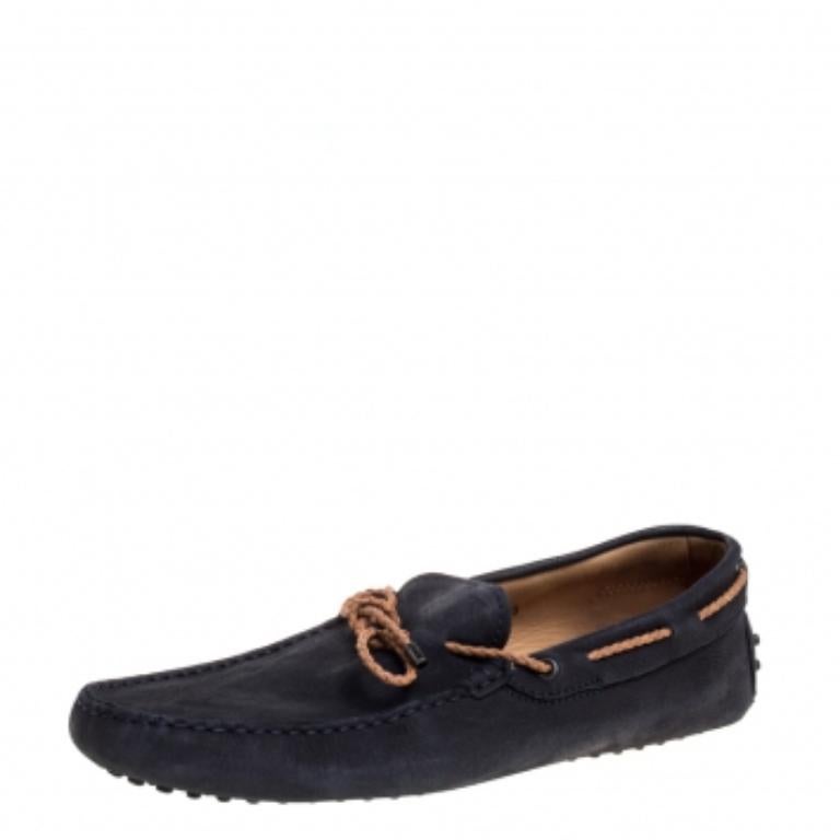 Crafted beautifully using suede and built to be durable, this pair of navy blue loafers by Tod's is a footwear must-have! The shoes feature perfect stitching, braided leather bow trims, leather insoles, and rubber soles.