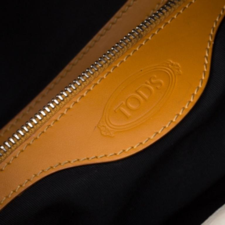 Tod's hobo is ideal for everyday use. The bag is crafted from off-white leather and features two slip pockets on each side. The top zip closure opens to a fabric lined interior that houses a zip pocket and the bag is complete with a shoulder strap.