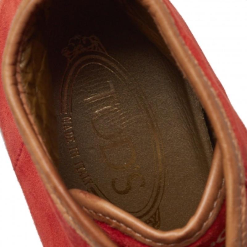 Bring home the luxurious high-fashion touch with these high-top sneakers from Tod's. Crafted from orange suede and brown leather, these sneakers flaunt round toes, lace-ups on the vamps, brand logo detailing on the tongues, and tough rubber soles.