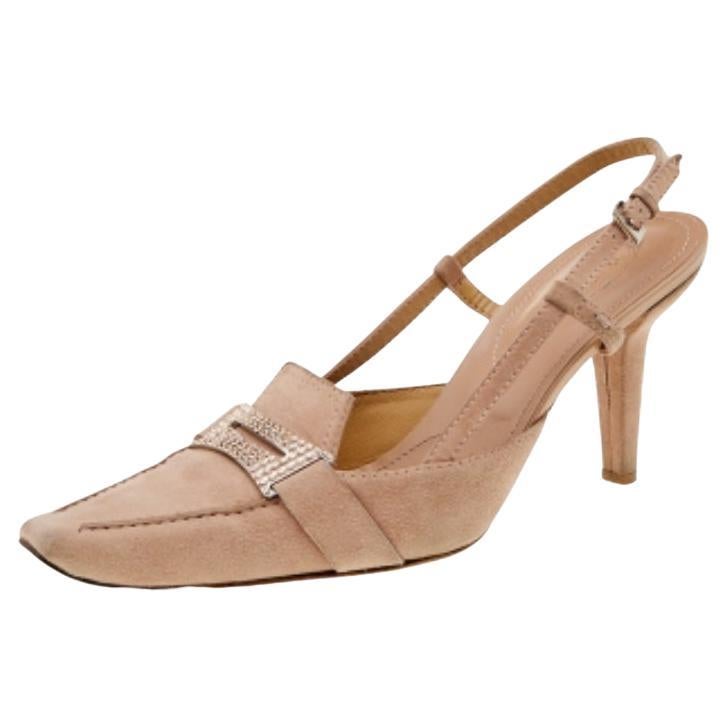 Look gorgeous as you walk in these loafer sandals from the House of Tod's. They are crafted using pale-pink suede, with a crystal-embellished Penny strap placed on the front. They showcase 9.5 cm heels, silver-tone hardware, and a slingback. Make a