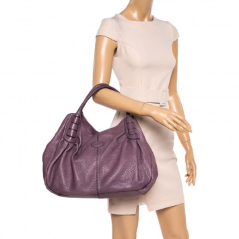 This Ivy Sacca Media hobo by Tod's is brought to you with love. On its purple-hued leather body, there are neat details running in perfect symmetry, two handles on top, and a spacious fabric interior. You will be delighted to have it as yours. It is