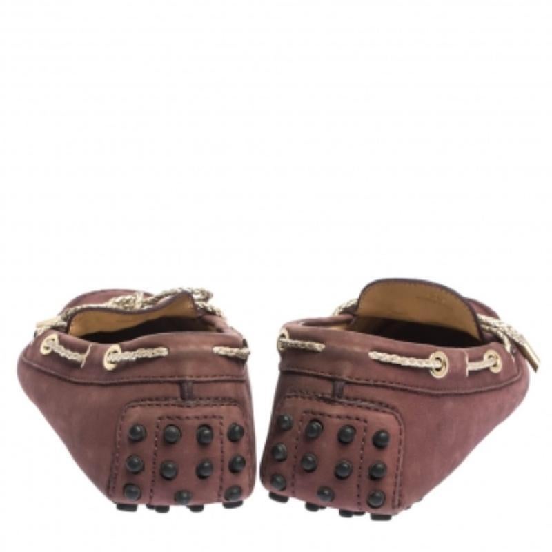 Ces mocassins mauves de Tod's sont non seulement très attrayants, mais aussi très bien réalisés. Elles ont été confectionnées en Italie à partir de nubuck et de cuir doré et sont dotées d'un nœud sur l'empeigne. Les mocassins ont une forme
