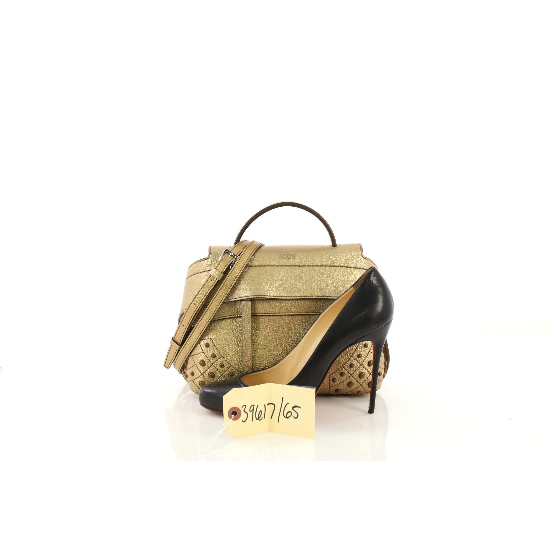 This Tod's Studded Convertible Wave Bag Leather Mini, crafted from gold metallic leather, features flat leather top handle, wide front leather band with button fastening on the sides, multiple stud detailing on base corners, exterior back pocket