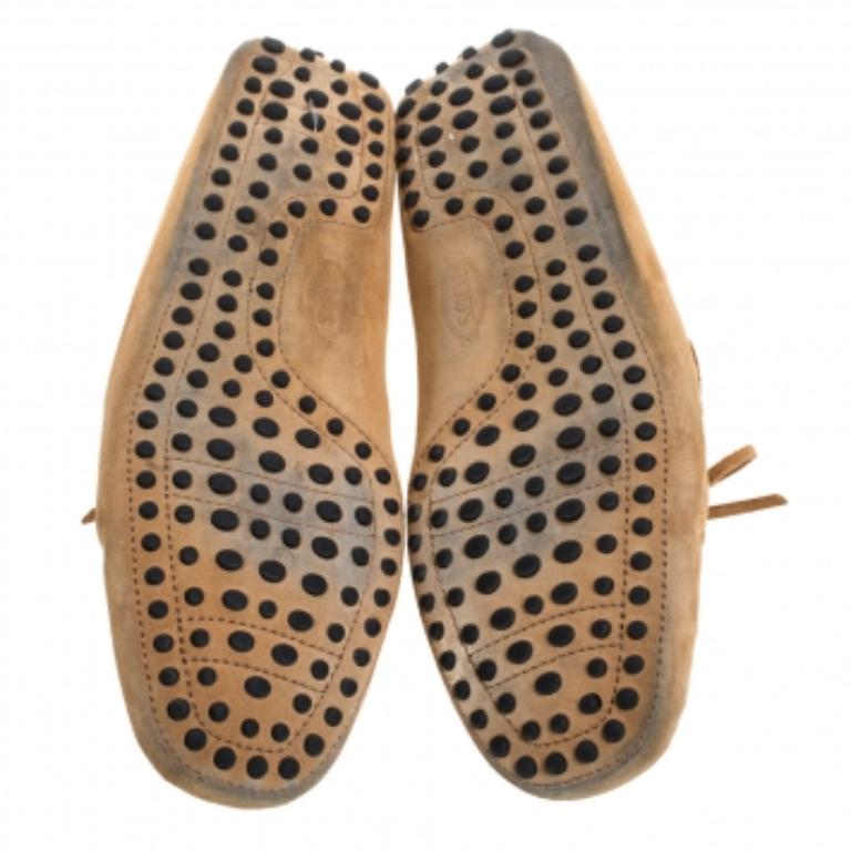 Versatile and super comfortable, these Gommino driving loafers from Tod's do deserve a place in your closet. They are eternal classics and made from suede in a tan hue. These loafers feature tie fastenings, stitching details, and the iconic rubber