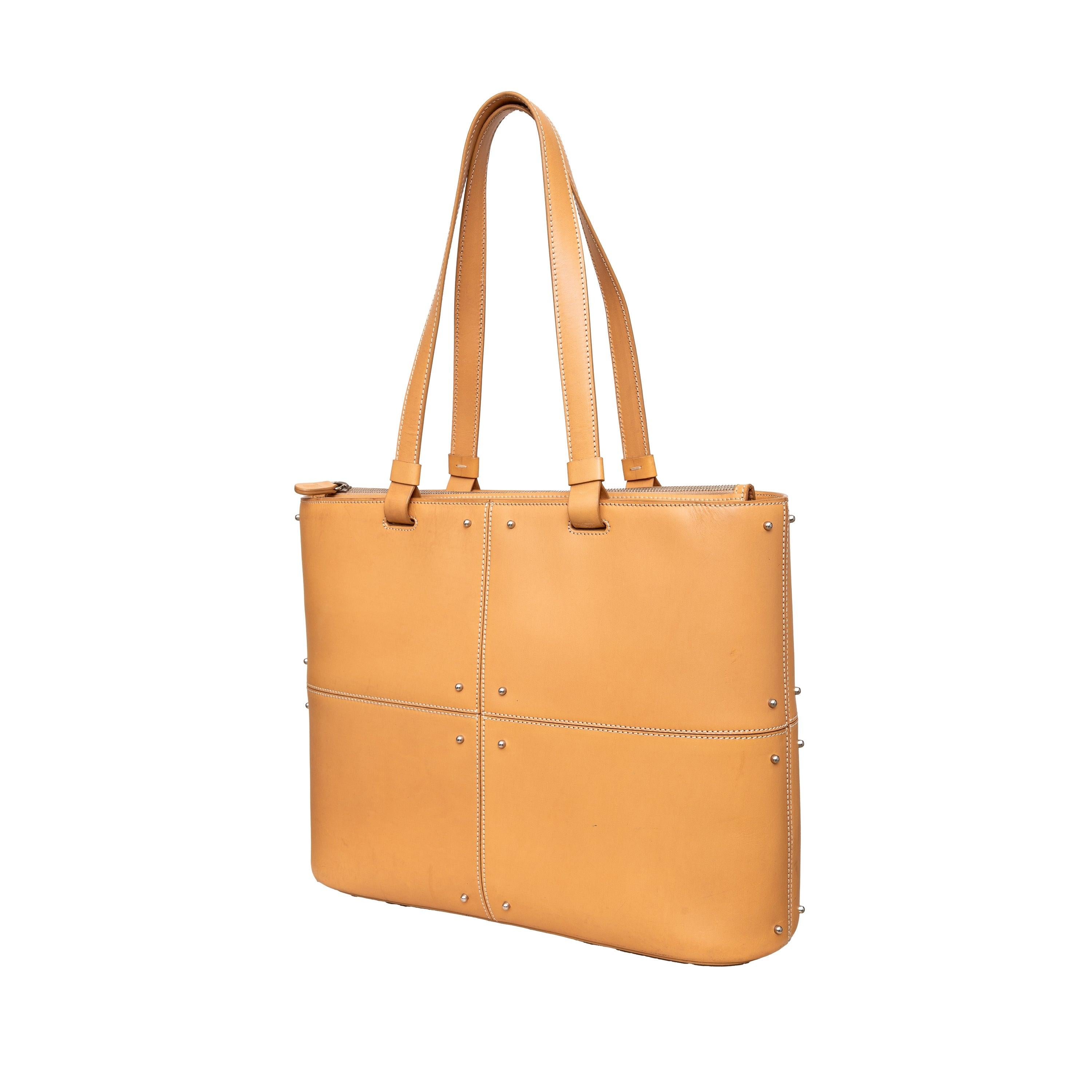 Introducing the Tod's Tote Bag featuring high-quality brown leather with visible seams and studs - chic and durable. The top zipper closure ensures security while the single spacious compartment and zippered pocket provide ample storage. Complete