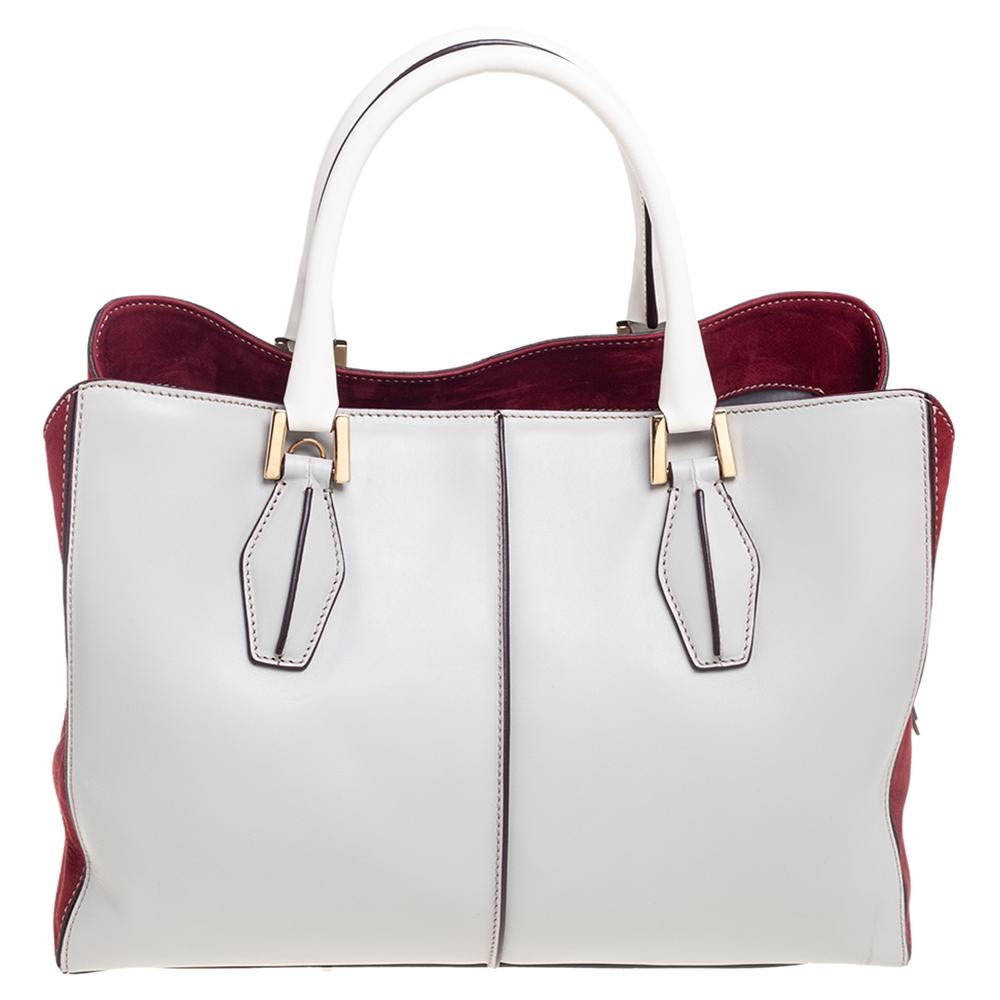 This elegant Tod's D-Cube tote makes a perfect everyday carryall or a weekend bag. It features a chic design with beautiful leather, suede, and gold-tone hardware. A long detachable leather strap can be worn over the shoulder for ultimate hands-free