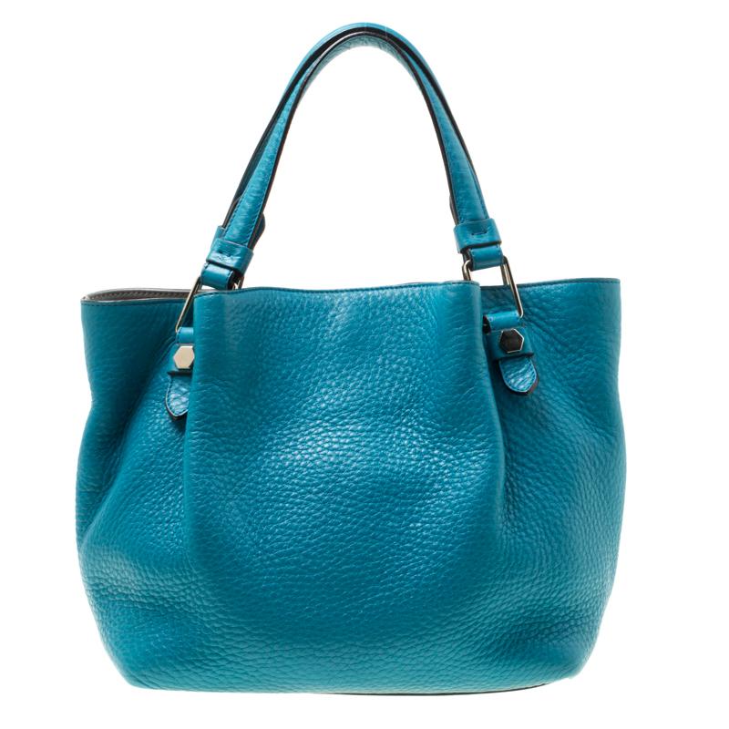 This refreshing shoulder bag from Tod's is crafted from turquoise leather. Well crafted, the bag comes with dual handles, a removable shoulder strap and a fabric lined interior. Secured by snap button closure, the interior is sized to hold all your