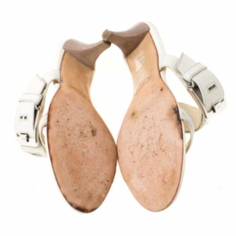 Questo elegante paio di sandali è di Tod's. Realizzate in pelle, sono dotate di fibbia argentata sul cinturino largo. I sandali bianchi sono bilanciati su tacchi impilati. Dal design versatile, i sandali possono essere abbinati a qualsiasi outfit.
