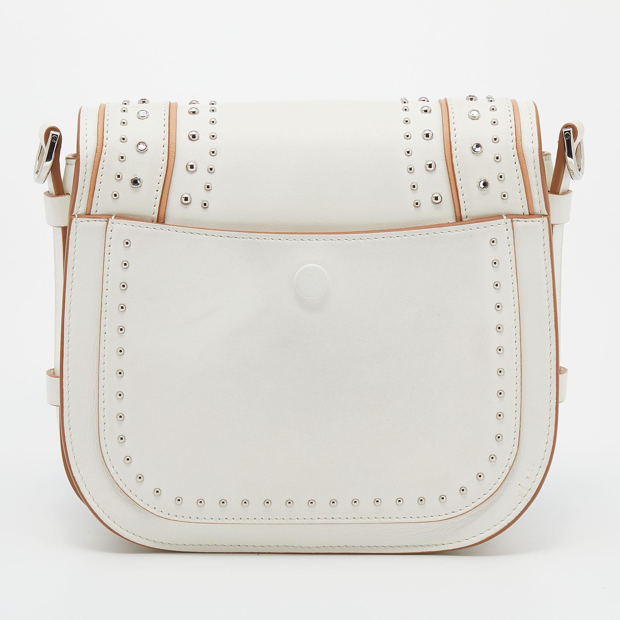 This T Saddle bag from the House of Tod's is both elegant and fashionable. Crafted from white leather, this bag features a shoulder strap, silver-tone hardware, and an Alcantara-lined interior. A logo accent is placed on the front. Make this