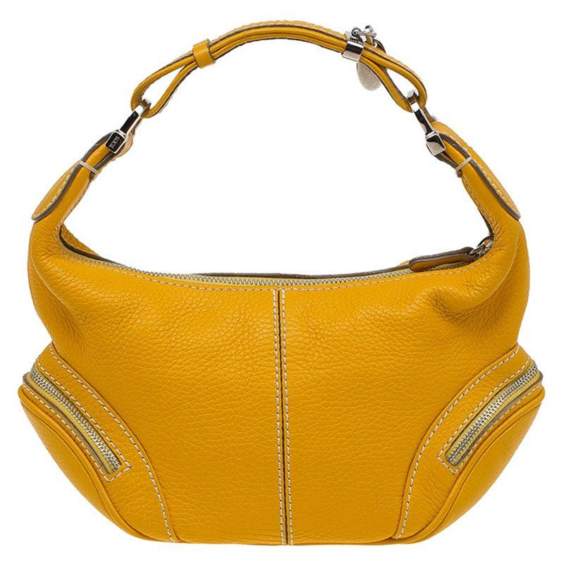 The Charlotte hobo from Tod’s is made of pebbled leather, with two exterior zippered pockets to hold small items. The fabric lining has one open pocket and is secured with a zip. The short flat handle with a Tod ‘T’ charm allows the bag to be